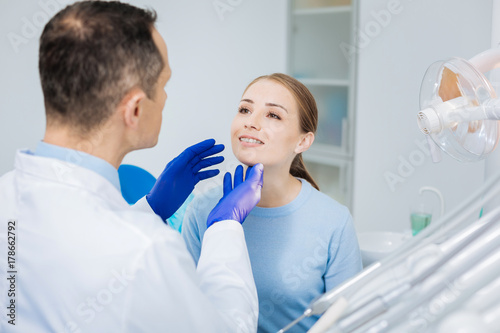 Nice pleasant woman looking at her doctor