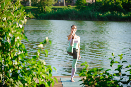 Young healthy woman practicing yoga at sunset