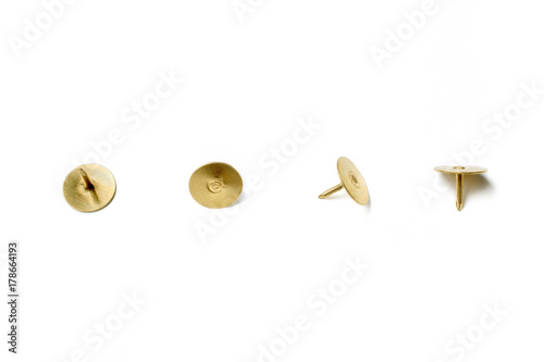 Small Collection Of 4 Brass Thumbtacks Arranged In A Line On White Background photo