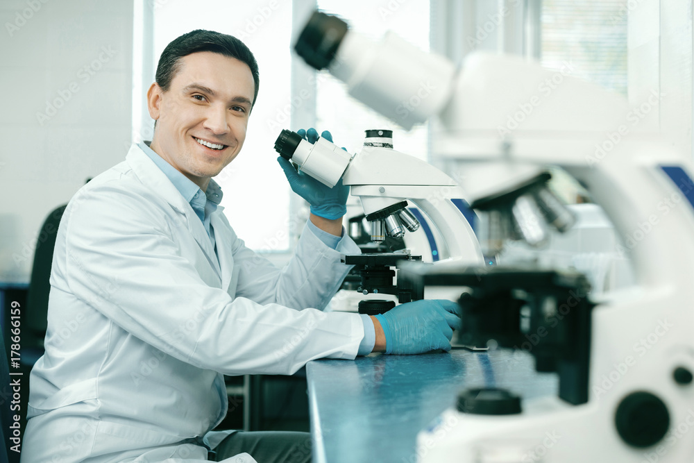 Positive delighted lab assistant looking straight at camera Positive delighted lab assistant looking straight at camera