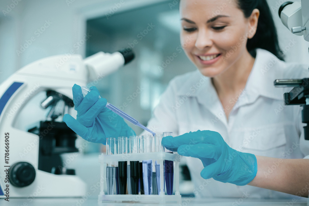 Fototapeta premium Careful lab assistant mixing reagents
