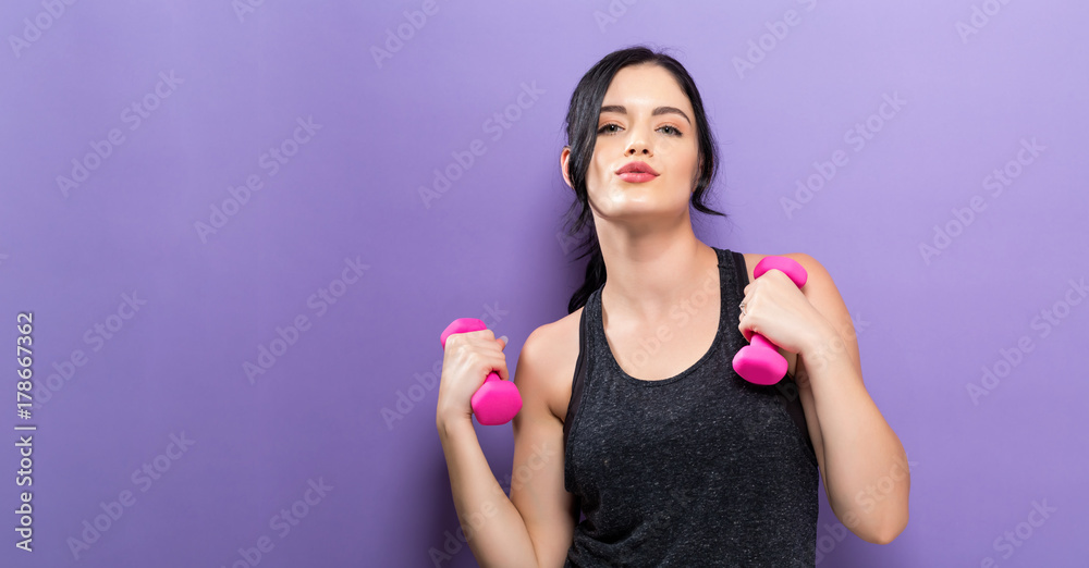 Happy young woman working out with dumbbell Happy young woman working out with dumbbell