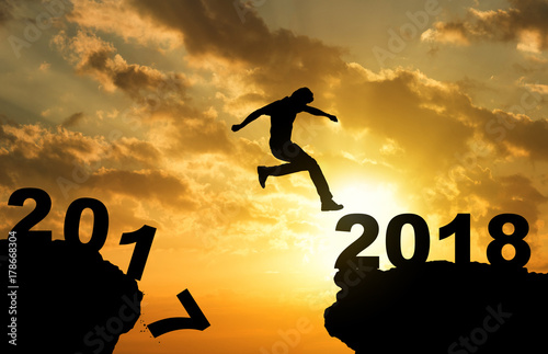 Man jumping over precipice on sunset background , 2018 new year calendar concept