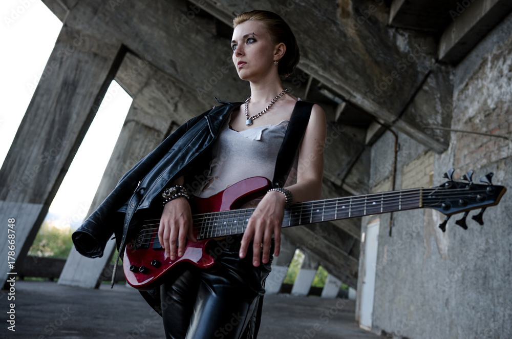 Beautiful girl with red bass guitar. Rockstar style Photos | Adobe Stock