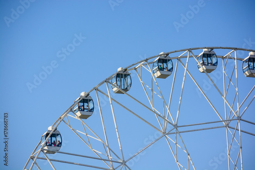 Close up modern Ferris wheel against blue sky