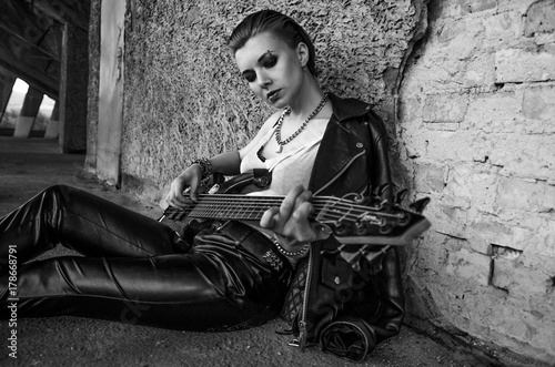 Close-up photo of electric guitar player in leather jacket.  Black and white photo