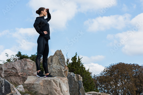 woman standing on rocks and looking away