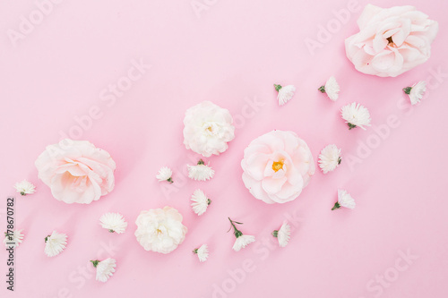 White roses flowers and chrysanthemums arrangement on pink background. Flat lay, top view. Floral background.