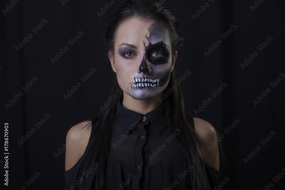 Halloween. Portrait of young beautiful girl with make-up skeleton on her face Halloween. Portrait of young beautiful girl with make-up skeleton on her face