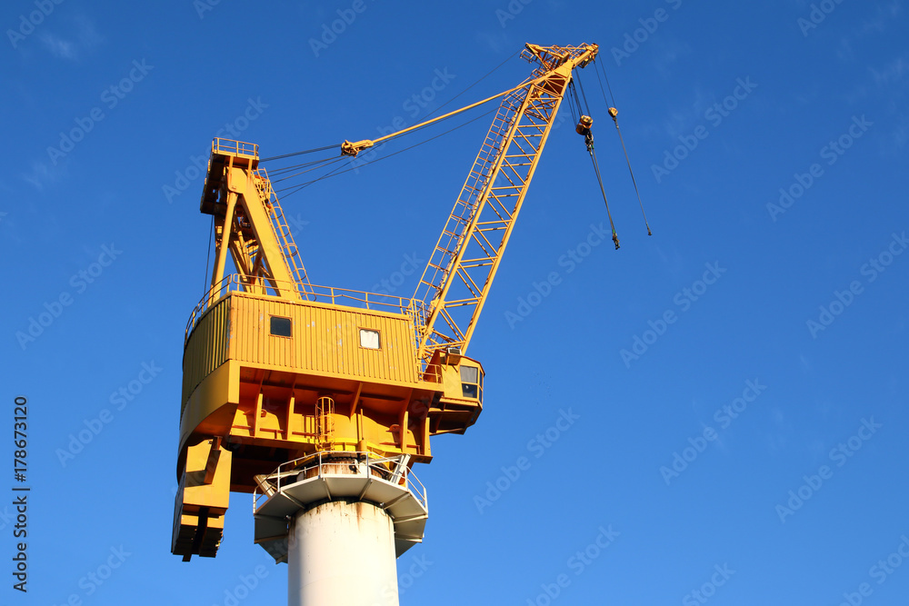 yellow crane in the shipyards of the port in a blue sky yellow crane in the shipyards of the port in a blue sky