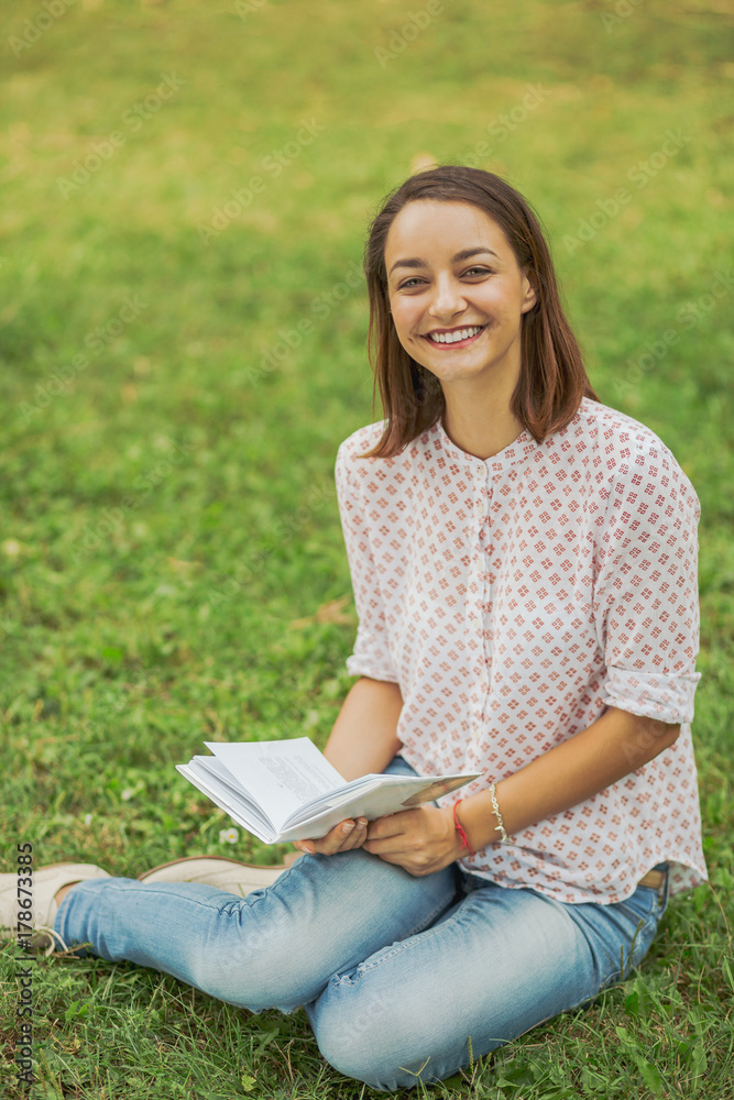 Obraz premium Cute young woman reading the book