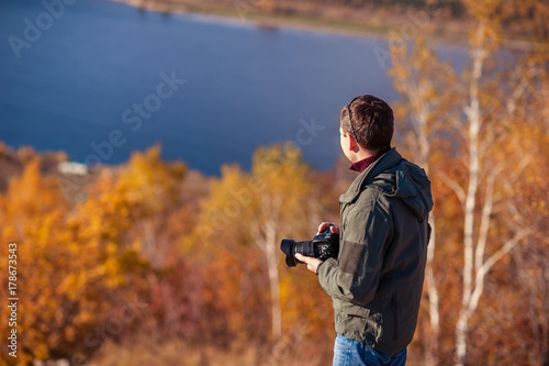 a man stands on top of a mountain and takes a picture of the landscape © Татьяна Бердо