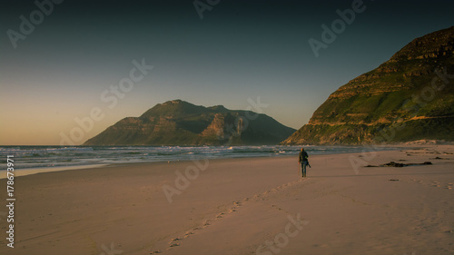 A lone walker on the beach at sunset near Cape Town, South Africa