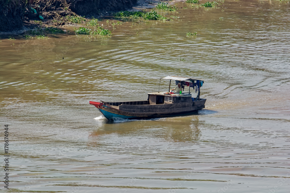 Fototapeta premium An old wooden boat float along the Soai Rap river shore