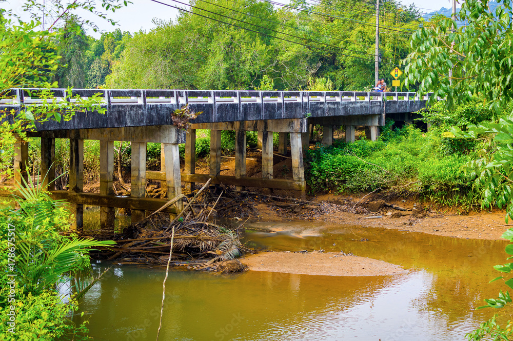 Landscape of stone bridge in rural region in Thailand. River after rain and flood