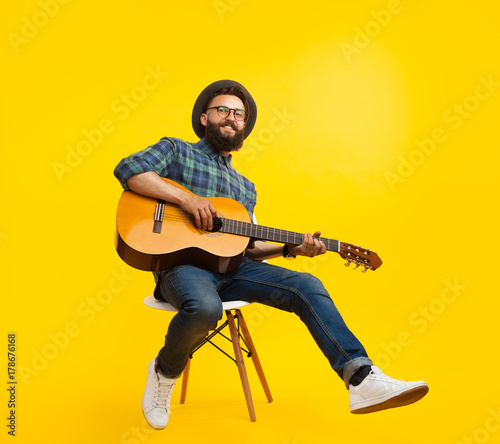 Stylish hipster playing guitar in studio © kegfire