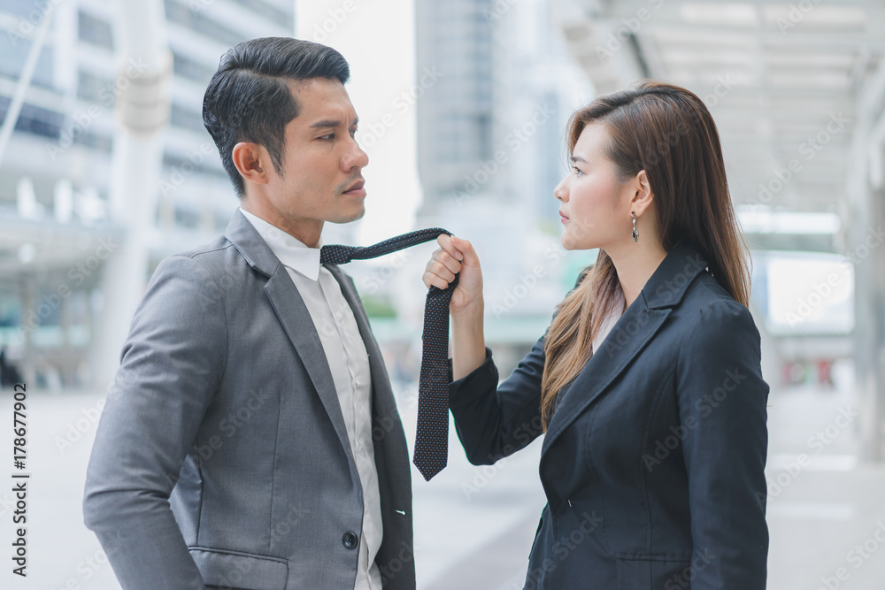 Businesswoman and businessman conflicting on cityscape background Businesswoman and businessman conflicting on cityscape background