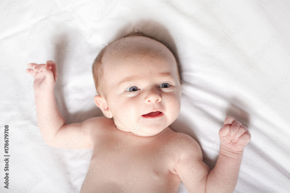 Peaceful baby lying on a bed on parent room Peaceful baby lying on a bed on parent room