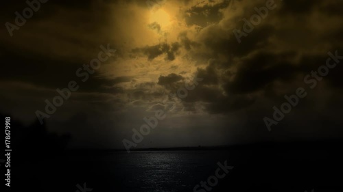 ''cloudy blue sky above a black surface of the sea'' photo