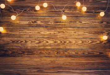 Old wooden planks with christmas decoration. Brown background with lightbulbs