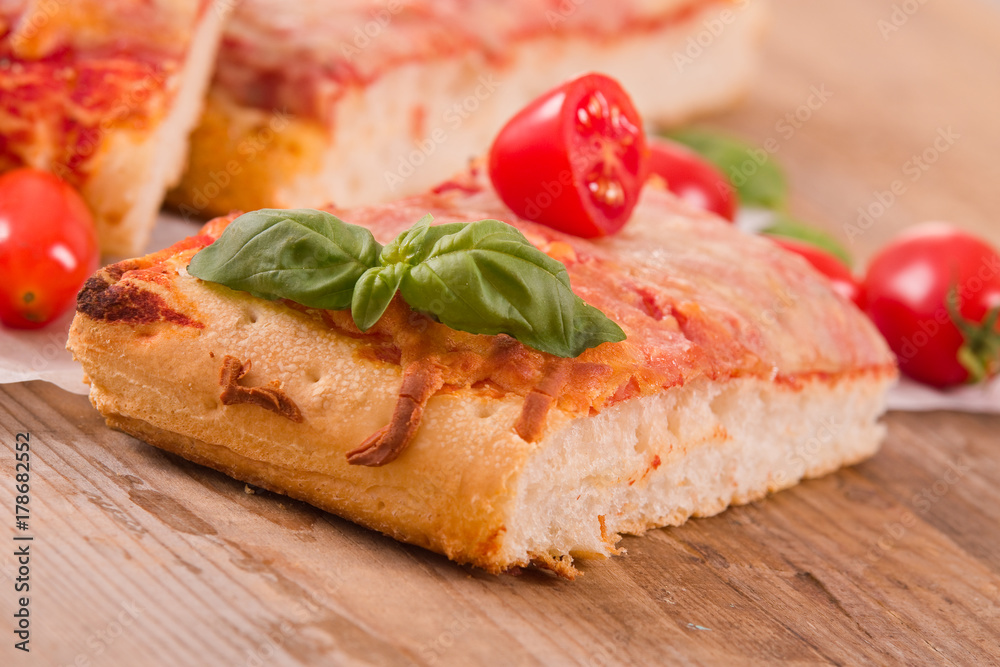 Italian pizza with cheese, tomatoes and fresh basil. 