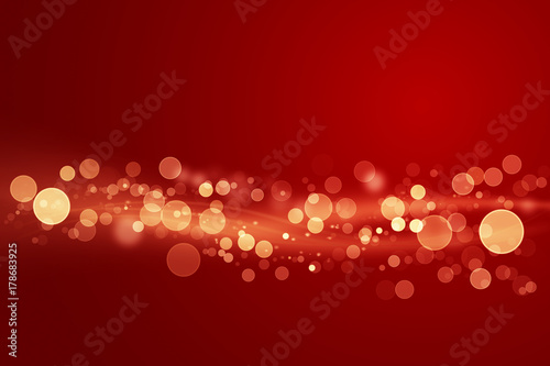 Abstract shiny color gold light wave design element with glitter bokeh effect on dark red background.