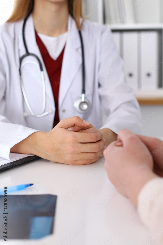 Close up of a doctor and patient hands while discussing medical records after health examination Close up of a doctor and patient hands while discussing medical records after health examination