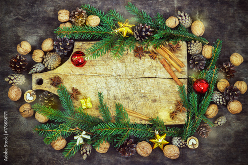 old cutting board with christmas attributes on a wooden kitchen background