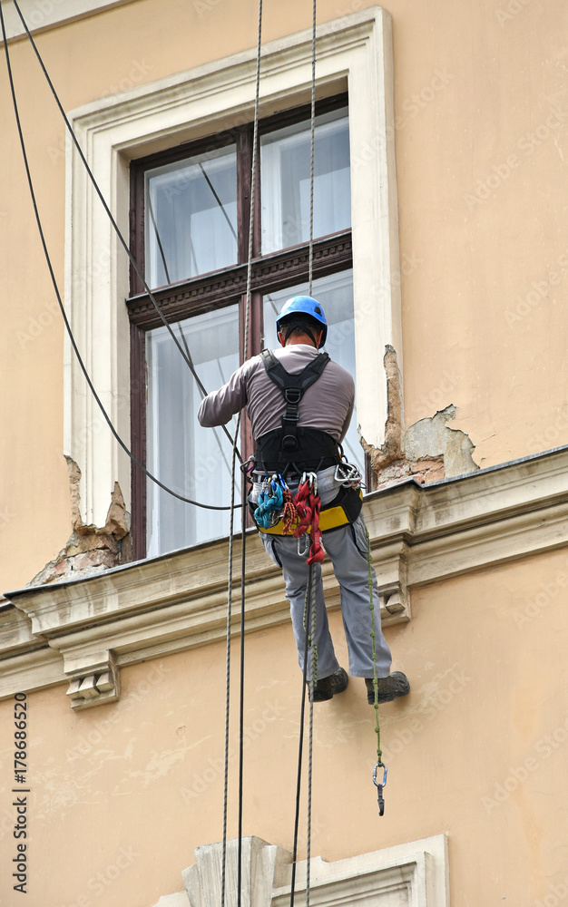 Construction worker at work on the wall of an old building