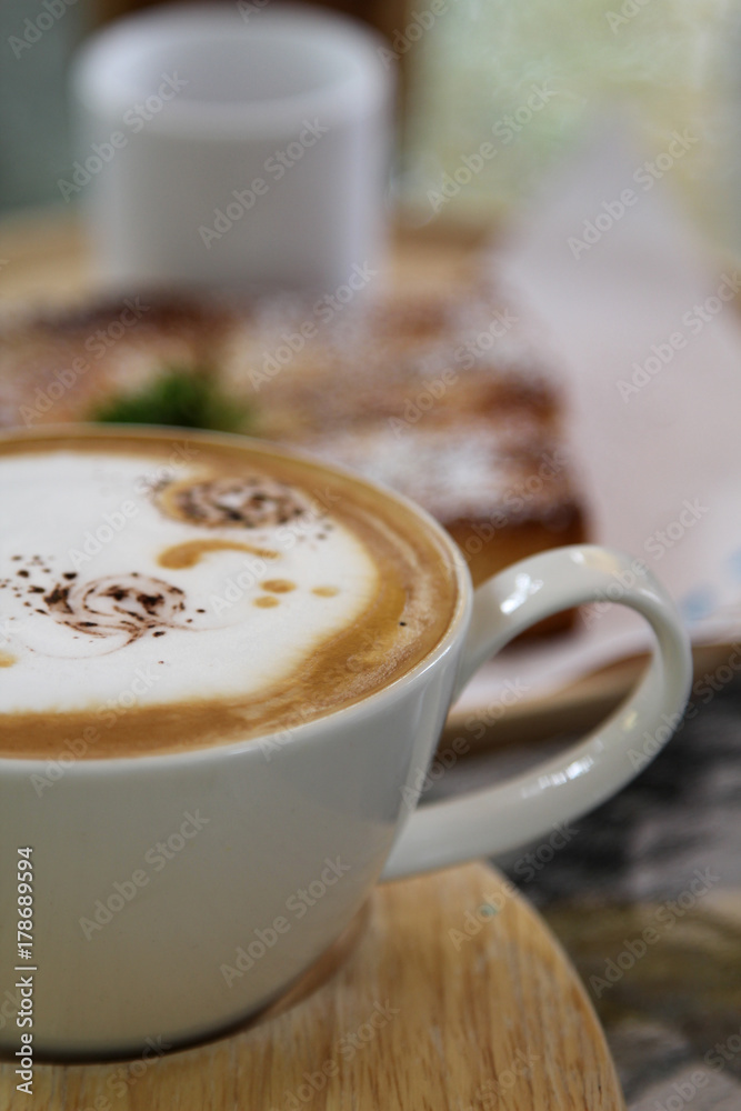Hot cappuccino on wooden tray in morning time.
