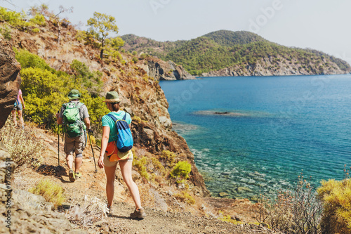Group of Hikers walking by Lycian Way trail along wild beach and mountains in Turkey