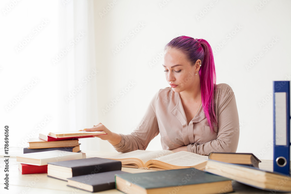 business woman with pink hair sits in the Office reads books education business woman with pink hair sits in the Office reads books education