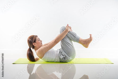 Pretty sporty blonde in doing yoga on white background