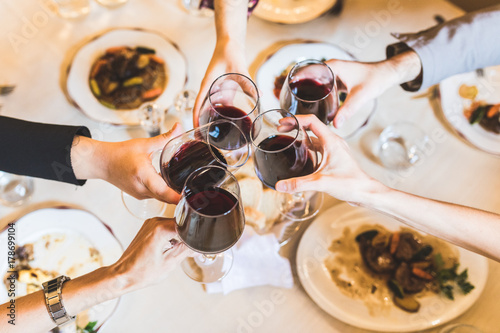 People toasting with red wine at restaurant