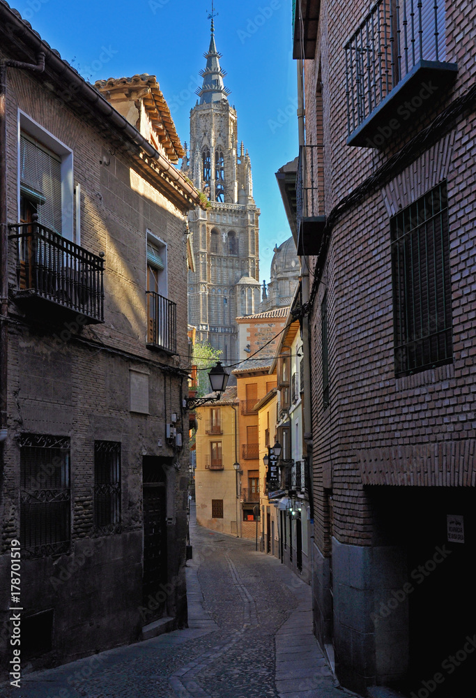 Narrow street opening to a high cathedral