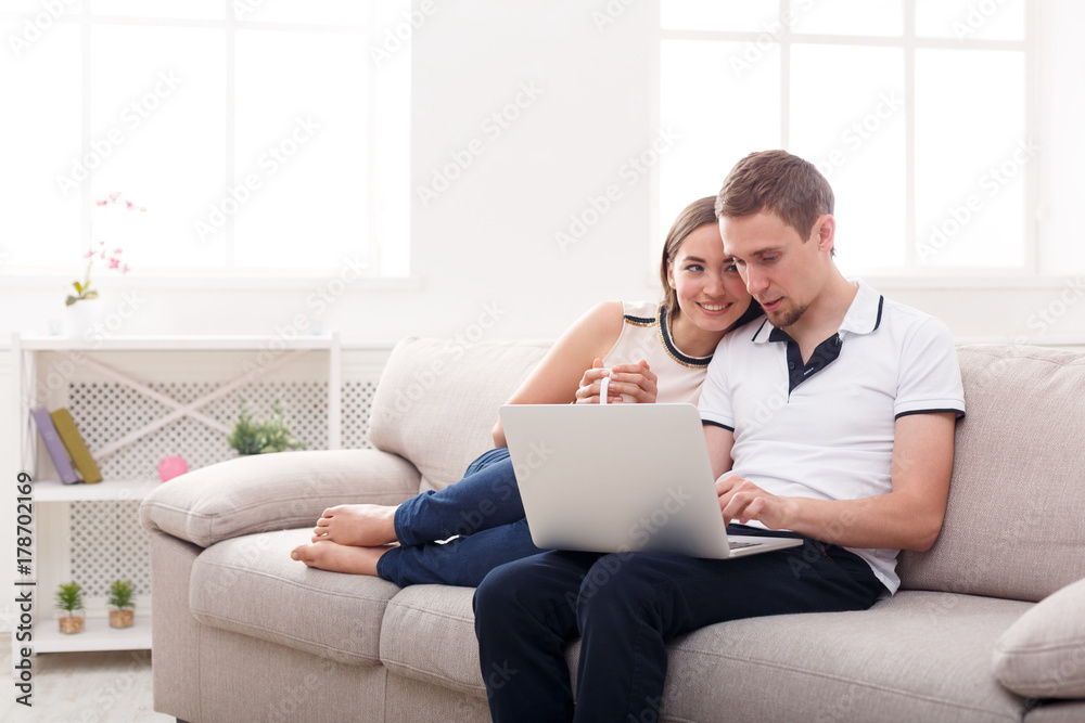 Young couple web surfing on laptop, copy space Young couple web surfing on laptop, copy space