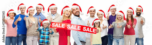 people in santa hats with sale sign at christmas