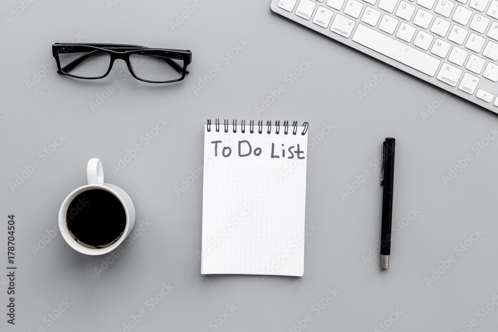 To do list for businessman in notebook on office table. Grey background top view To do list for businessman in notebook on office table. Grey background top view