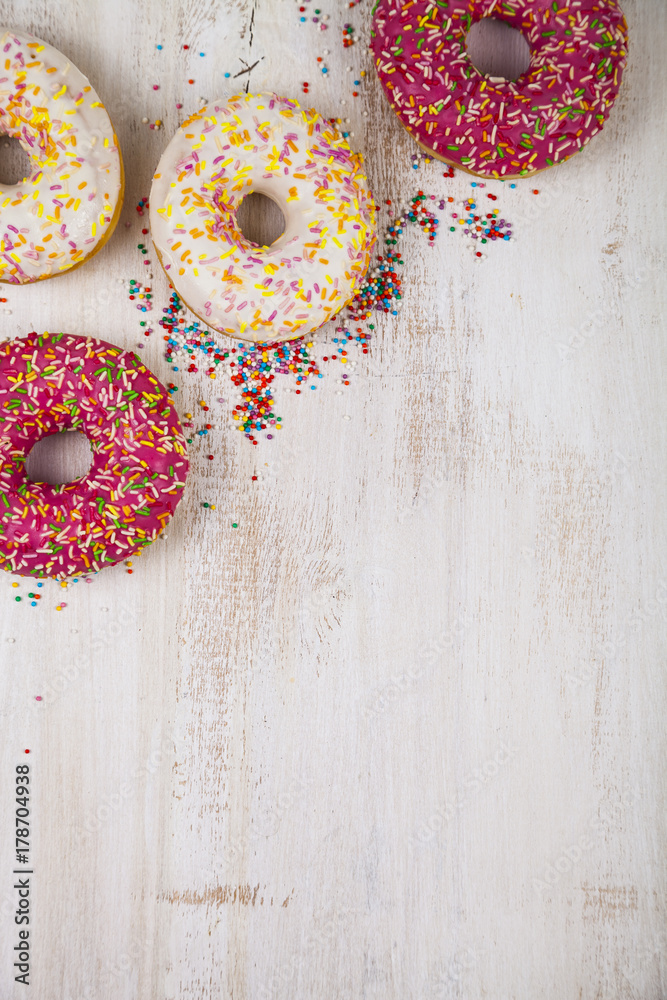 Multicolored donuts  on a wooden background.