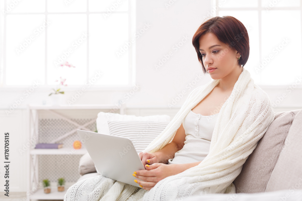 Home comfort. Thoughtful girl in a blanket using tablet Home comfort. Thoughtful girl in a blanket using tablet