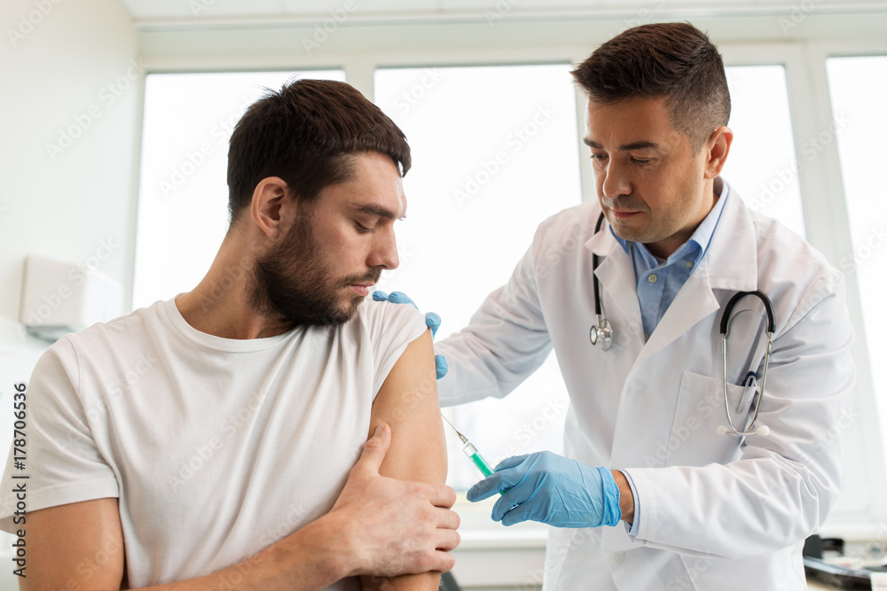 patient and doctor with syringe doing vaccination patient and doctor with syringe doing vaccination