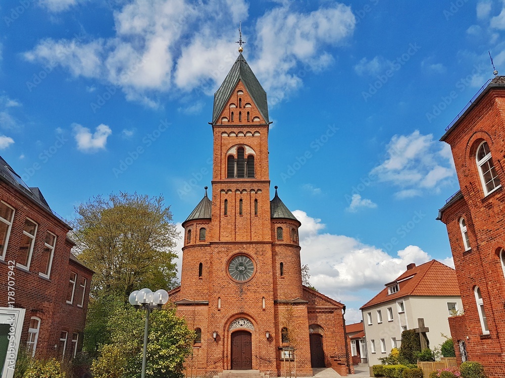 Fototapeta premium Facade of the Catholic Church against the blue sky, the city of Bremen