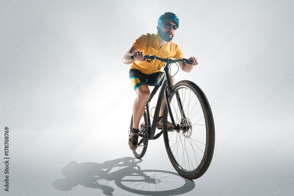 The bicyclist on gray, studio shot. The bicyclist on gray, studio shot.