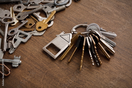 Bunch of keys with house trinklet on wooden table photo