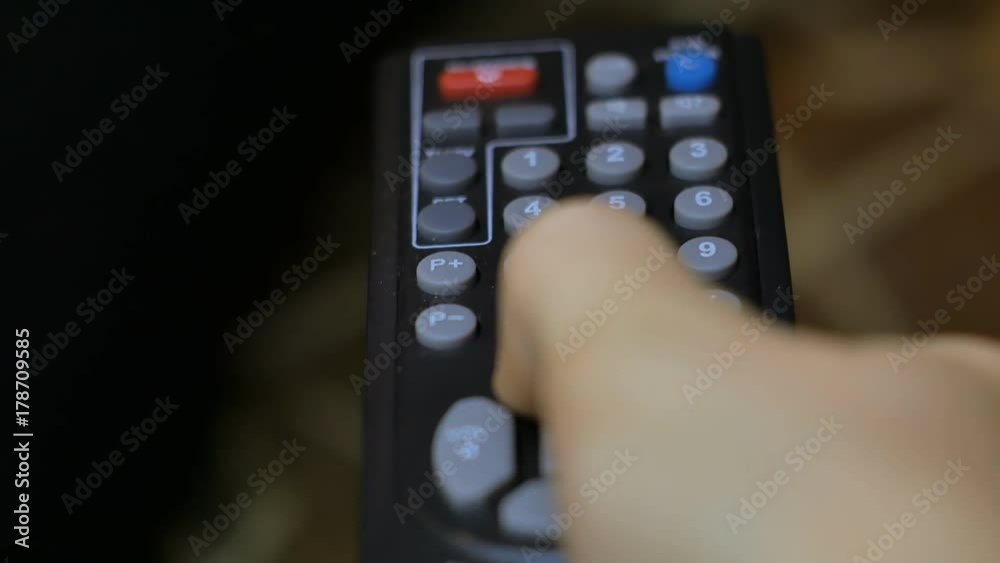 Hand presses remote control a close-up Hand presses remote control a close-up