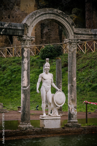 Details of the archaeological site of Villa Adriana with its central fountain and statues depicting Roman deities photo