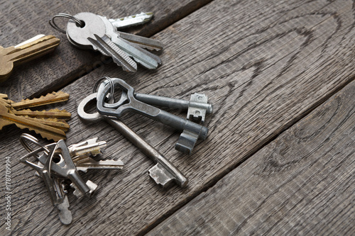 Set of new metal keys on aged wood © Prostock-studio
