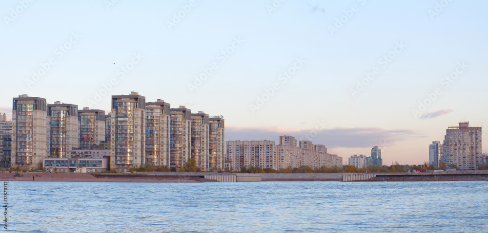 panorama of city blocks of tall buildings on the beach at sunset