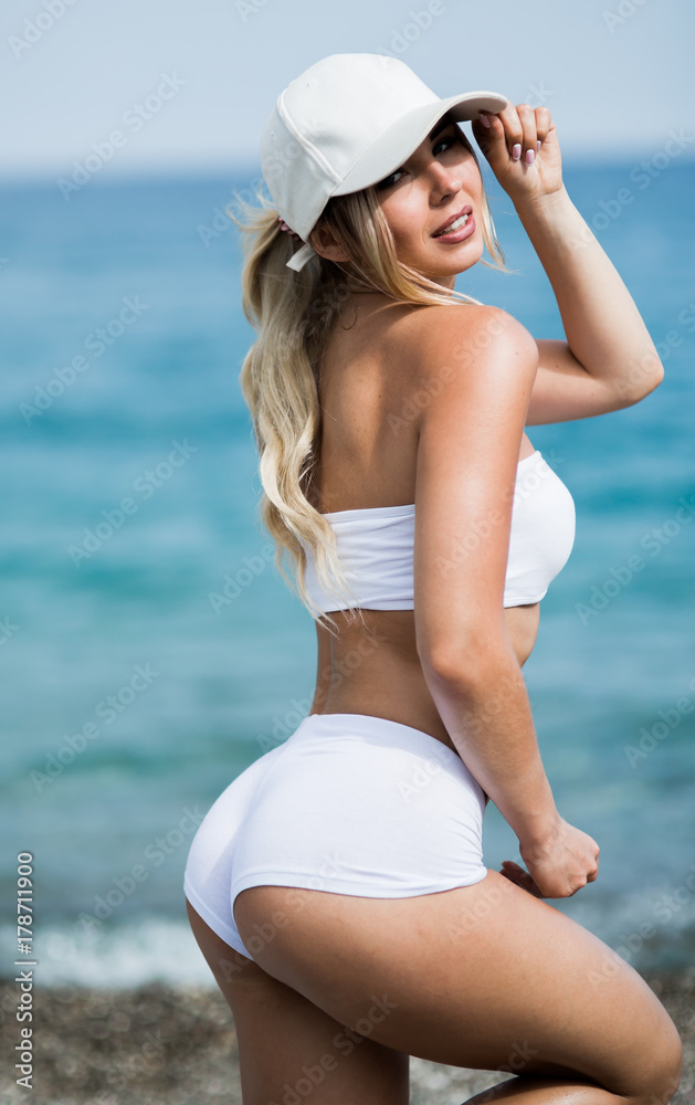 Fitness girl with a perfect body is smiling near the sea Fitness girl with a perfect body is smiling near the sea