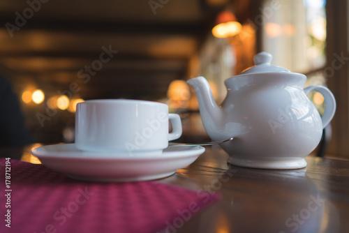 white teapot and cup on a wooden table